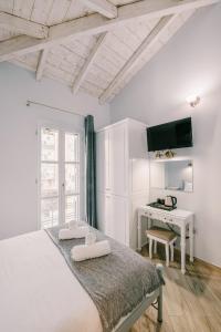 a white bedroom with a bed and a desk at Neapolis 1897 Boutique Luxury Rooms in Athens