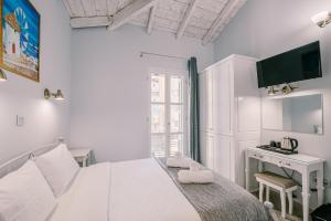 a white bedroom with a bed and a desk at Neapolis 1897 Boutique Luxury Rooms in Athens