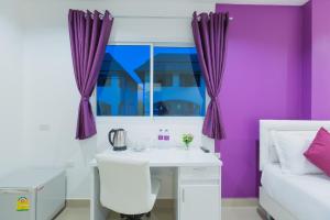 a bedroom with a white desk and purple walls at Z by Zing in Jomtien Beach