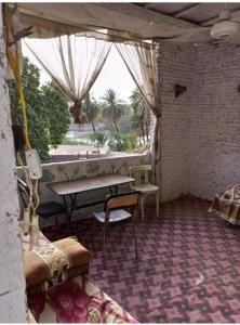 une chambre avec une table et des chaises dans un bâtiment dans l'établissement NUBA ONe, à Assouan