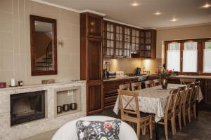a kitchen with a table with chairs and a fireplace at Hilltop Wellness Villa-big garden, sauna, hot tube in Pécs