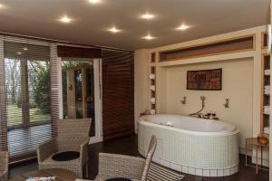 a bathroom with a tub and a table and chairs at Hilltop Wellness Villa-big garden, sauna, hot tube in Pécs +93 photos