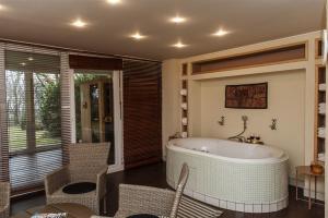 a bathroom with a tub and a table and chairs at Hilltop Wellness Villa-big garden, sauna, hot tube in Pécs