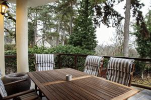 a wooden table and two chairs on a porch at Hilltop Wellness Villa-big garden, sauna, hot tube in Pécs