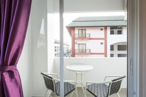 - une table et des chaises dans une chambre avec fenêtre dans l'établissement Z by Zing, à Jomtien Beach