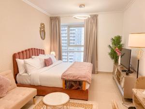 una camera con letto, divano e finestra di Cosmos Living Cozy Studio Near Dubai Marina a Dubai