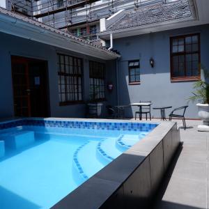 a large swimming pool in front of a house at The City Club in Cape Town