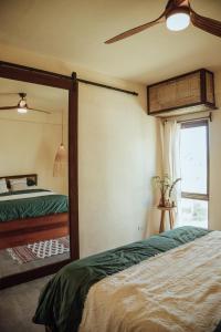 - une chambre avec un miroir, un lit et une fenêtre dans l'établissement Vedya Boutique Hostel, à General Luna