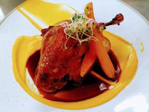 um prato de comida com frango e cenouras em Ratanui Lodge em Pohara