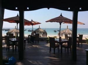 ein Restaurant am Strand mit Tischen und Sonnenschirmen in der Unterkunft Yoma Cherry Lodge in Ngapali