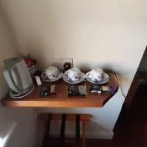 uma pequena mesa com pratos e uma televisão em Kingdom Lodge em Killarney
