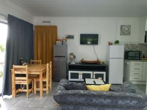 ein Wohnzimmer mit einem Sofa und einem Tisch in der Unterkunft Bee Comfy in Klein-Brakrivier