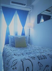 a blue bedroom with a bed with birds on it at SMDC COAST RESIDENCES in Manila