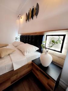 a bedroom with a bed with a vase on a table at House of Chess Luxury Villa in Satu Mare