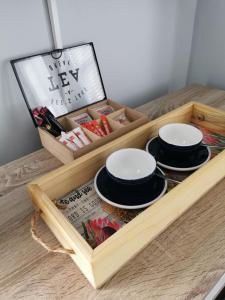 eine Holzkiste mit drei Tellern und einer Zeitschrift in der Unterkunft Huis van Brood Guesthouse in Malmesbury
