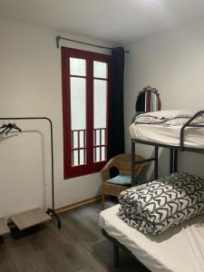 um quarto com 2 beliches e uma janela em Tarragona Hostel em Tarragona