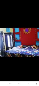 Shiva lodge في فاراناسي: غرفة نوم مع سرير بورد احمر الراس