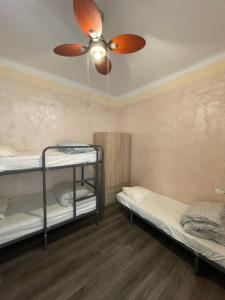 a room with two bunk beds and a ceiling fan at Tarragona Hostel in Tarragona