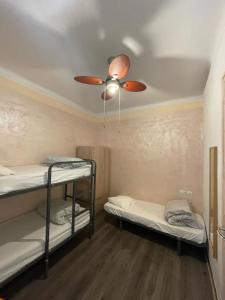 a room with two bunk beds and a ceiling fan at Tarragona Hostel in Tarragona