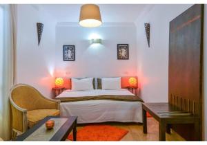 a small bedroom with a bed and a table at L'AUBERGE DE TENNIS MSC in Marrakech +33 photos