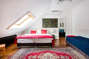a bedroom with a bed with red pillows and a rug at Cecile's Central, Gastro str, WIFI, 2 bed and 2 bathrooms in Budapest