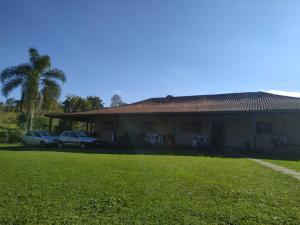 a house with two cars parked in front of it at Sitio do Campo Fasan in Santa Isabel