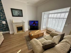 salon z kanapą i kominkiem w obiekcie Spacious one bedroom apartment in central location w mieście Lytham St Annes