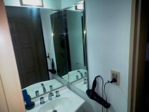 een badkamer met een wastafel en een grote spiegel bij La Tranquilidad Soñada in Mendoza