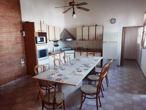 een keuken met een lange tafel met stoelen en apparatuur bij La Tranquilidad Soñada in Mendoza