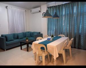 ein Wohnzimmer mit einem Tisch und einem blauen Sofa in der Unterkunft GLC SUITES in Bislig