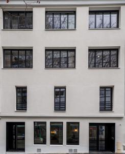 a facade of a white building with black windows at Beau M Paris in Paris