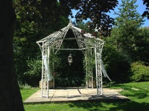 a gazebo with a chandelier in a garden at Heath Cottage Hotel in Dewsbury