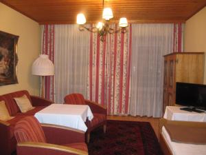 a hotel room with a couch and a tv at Goldener Ochs in Golling an der Salzach