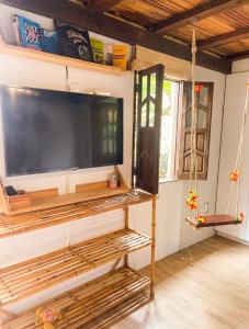 a living room with a large flat screen tv on a wall at Casa no coração de Praia do Forte in Praia do Forte