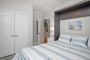 a white bedroom with a large bed with a wooden headboard at Salty Girl in Oak Island