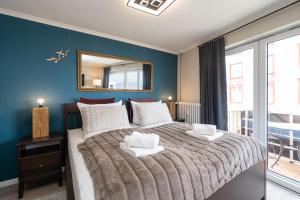 a bedroom with a large bed with a mirror on the wall at Meerliebe in Westerland (Sylt)