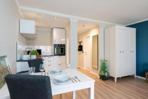 a kitchen and living room with a white table and chairs at Meerliebe in Westerland (Sylt)