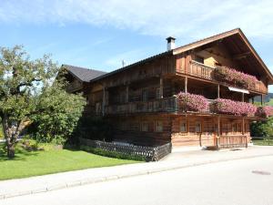 a large wooden house with flowers on the balcony at Apartment near the ski area and lake in Reith im Alpbachtal