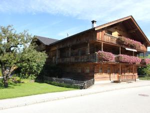 a large wooden house with flowers on the balcony at Exquisite Apartment in Reith im Alpbachtal near Ski Resort and Lake in Reith im Alpbachtal