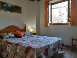 um quarto com uma cama com uma colcha em Apartamento planta baja con jardín Isard 3 em Pla de l'Ermita