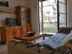 uma sala de estar com uma televisão e uma mesa de centro em Apartamento planta baja con jardín Isard 3 em Pla de l'Ermita