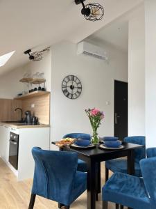 uma cozinha e sala de jantar com uma mesa e cadeiras azuis em Loft apart Pluzine em Pluzine