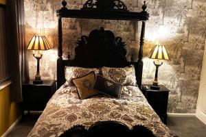 um quarto com uma cama grande e 2 candeeiros em Palm View Luxury Botanical Themed apartment with sauna em St Austell