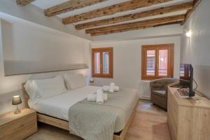 een slaapkamer met een bed, een televisie en een stoel bij Ecco Suites Apartments in Venetië
