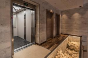 Hotel NERU con Encanto في ليون: غرفة مصعد فارغة مع حوض سمك في الطابق