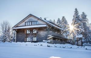 eine Blockhütte im Schnee mit Sonne in der Unterkunft Schettereggerhof in Egg