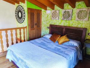 Suite Love في Gilgarcía: غرفة نوم بسرير وملاءات زرقاء وجدران خضراء
