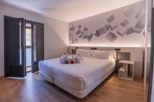 a bedroom with a large bed with two stuffed animals on it at Hotel NERU con Encanto in León