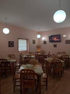 a dining room with tables and chairs and lights at La Salmonera Cangas de Onís in Caño