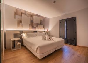 a bedroom with a large white bed in a room at Hotel NERU con Encanto in León